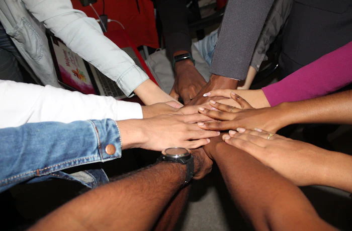 Diverse group of hands stacked together, symbolising unity and partnership
